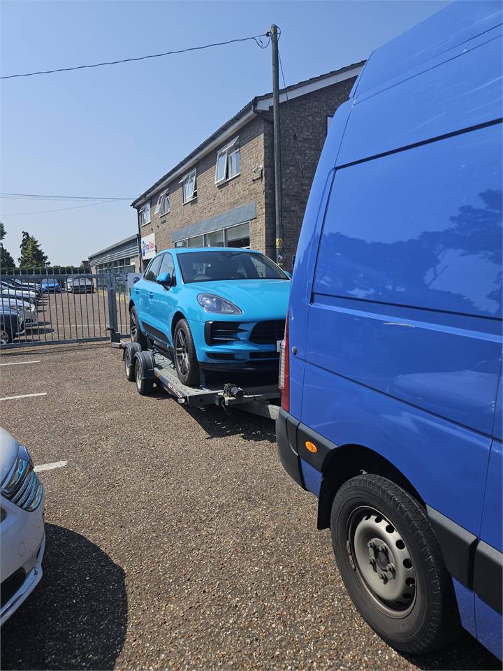 Blue Porsche transported on a trailer